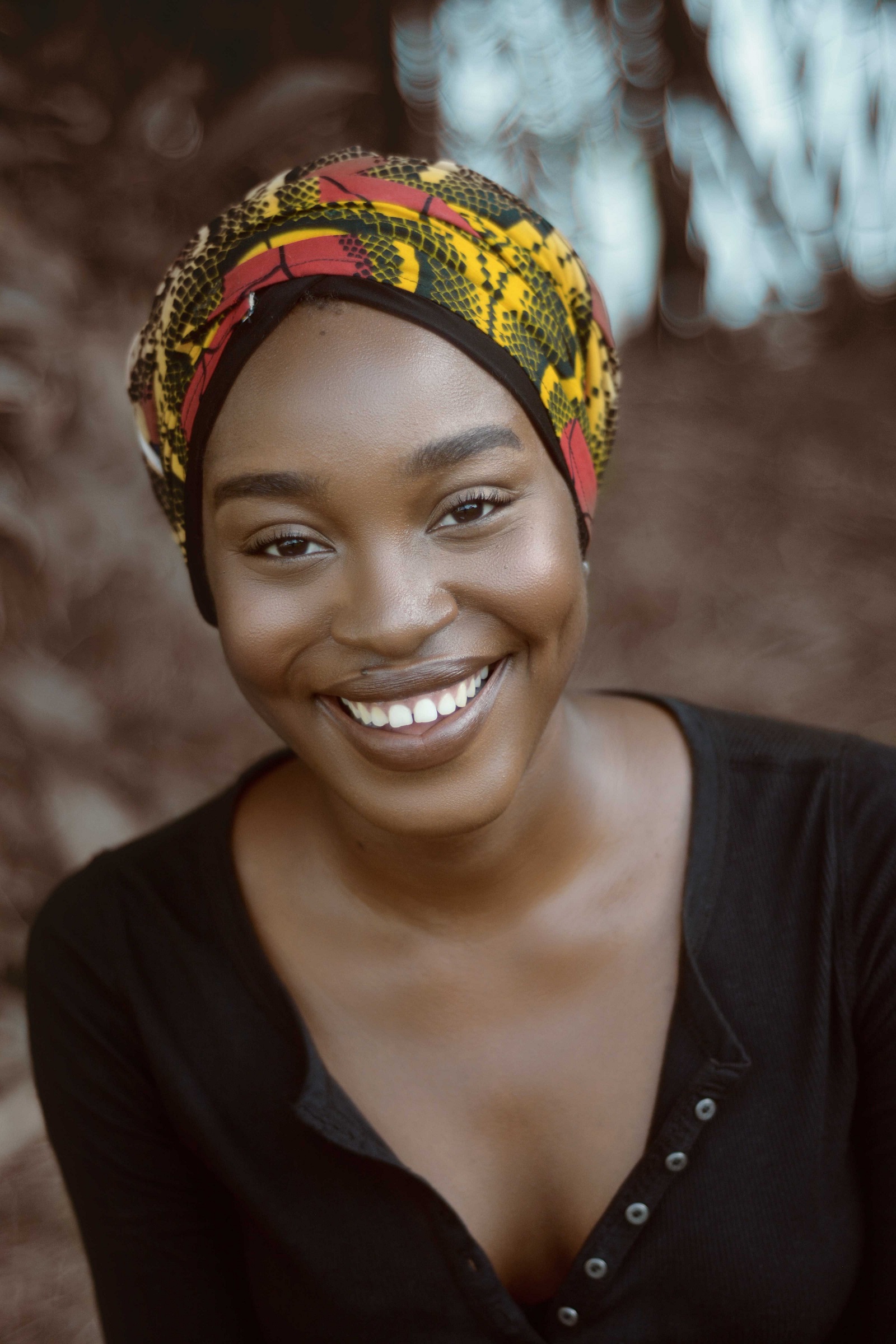 Author, Claire Singara smiling at the camera wearing a black shirt and head wrap.